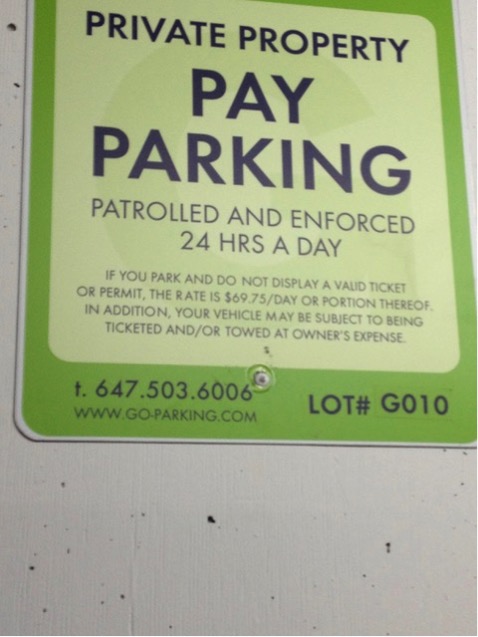 Paid parking sign with instructions and contact information