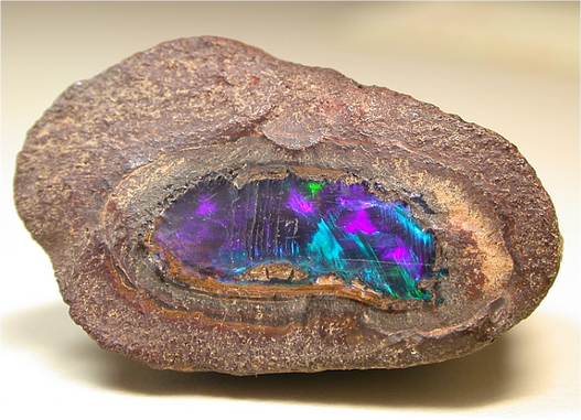 A rock with the inner layer exposed to reveal a multi-coloured gem